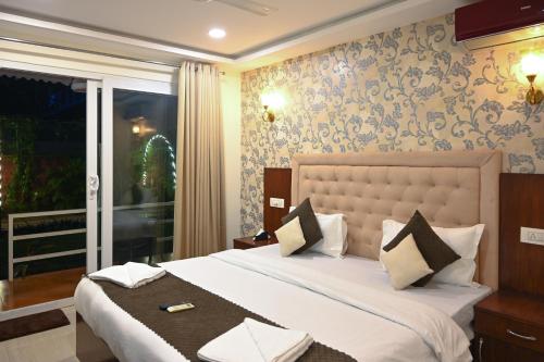une chambre avec un grand lit et une fenêtre dans l'établissement Arabian Sea Beach Resort, à Morjim