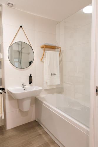 a bathroom with a sink and a tub and a mirror at Casa das Faias - Serra da Estrela in Manteigas