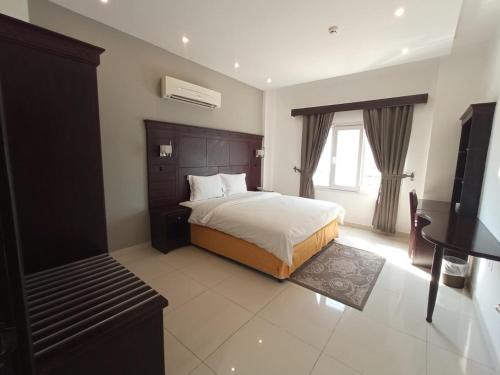マスカットにあるAsfar Hotel Apartmentsのベッドルーム(ベッド1台、ピアノ付)
