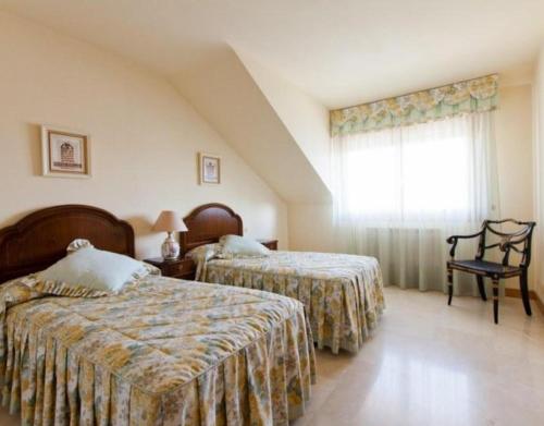 a hotel room with two beds and a window at Casa Senda Bardenas in Cabanillas