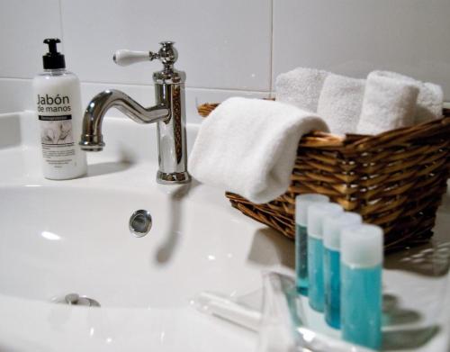 a bathroom sink with a basket of towels and a bottle of soap at Casa Senda Bardenas in Cabanillas