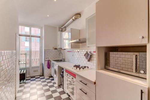 - une cuisine avec des placards blancs et un sol en damier dans l'établissement Lovely 2 bedroom Apartment in Nice with Balcony, à Nice