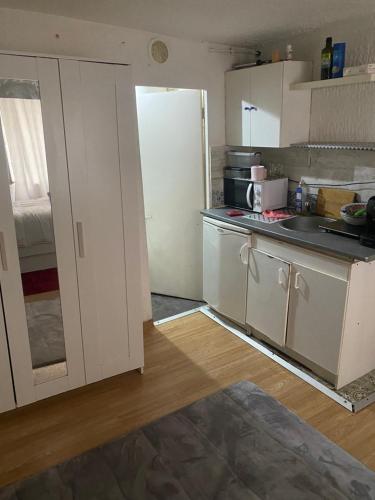  La cuisine est équipée de placards blancs et d'un réfrigérateur. dans l'établissement Djawed, à Paris