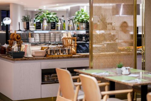 Baltic Park Loft by Zdrojowa في سفينويتشي: مطعم مع كونتر مع طاولة وكراسي