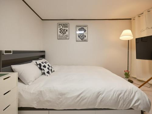 a bedroom with a white bed and a lamp at Warm Place in Seoul