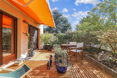 a wooden deck with a table and plants on it at Charmant Appart, terrasse verdoyante, proche Paris in Saint-Maur-des-Fossés