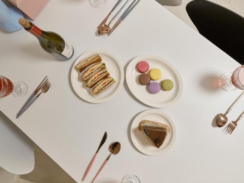 a white table with plates of desserts and forks at Warm Place in Seoul