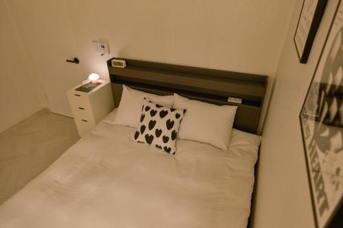 a small bedroom with a bed with two pillows at Warm Place in Seoul
