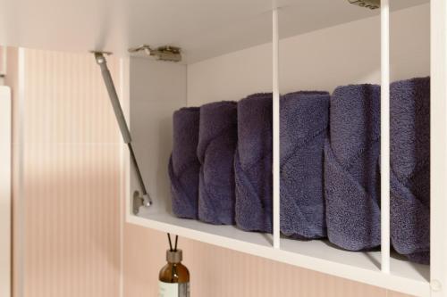 a row of purple towels on a shelf in a bathroom at Warm Place in Seoul