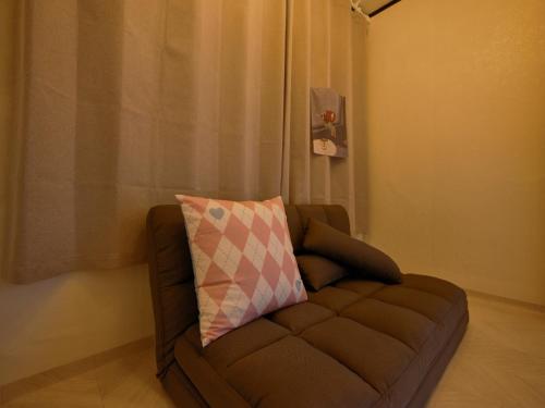 a brown couch with a pillow on top of it at Warm Place in Seoul