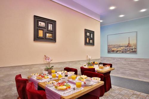 uma sala de jantar com mesas e cadeiras com comida em Avangard Hotel em São Petersburgo