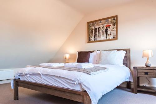 a bedroom with a large bed with white sheets at Camstay New Street in Cambridge
