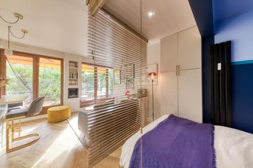 a bedroom with a bed and a desk and a table at Charmant Appart, terrasse verdoyante, proche Paris in Saint-Maur-des-Fossés