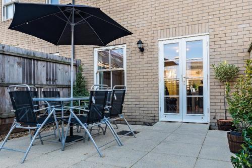 a table and chairs with an umbrella on a patio at Camstay New Street in Cambridge