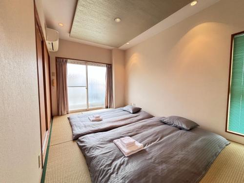 two beds in a small room with a window at 晴の松 in Wakayama