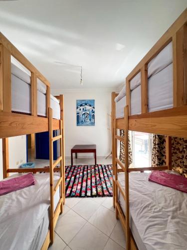 a room with three bunk beds and a table at Locals Taghazout surfcamp in Taghazout
