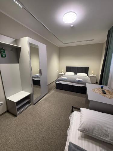 a large bedroom with a bed and a mirror at Ресторан-Готель Шеркерт in Berehove