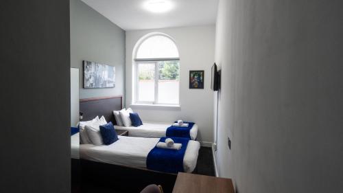 a hotel room with two beds and a window at Imperial Salford Hotel in Manchester