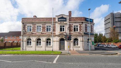 an old building on the corner of a street at Imperial Salford Hotel in Manchester