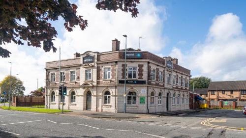 an old brick building on the corner of a street at Imperial Salford Hotel in Manchester