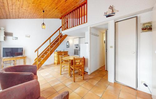 - un salon avec un escalier, une table et des chaises dans l'établissement 1 Bedroom Stunning Home In Vaux-Sur-Mer, à Vaux-sur-Mer