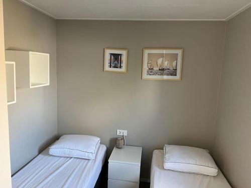 a room with two beds and two pictures on the wall at Cube 8 - Neues Ferienhaus im Ferienpark am Badesee in Lathum