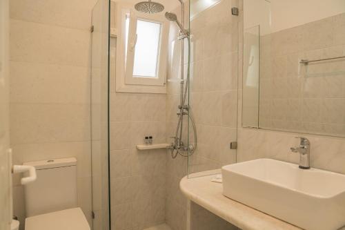 a bathroom with a toilet and a sink and a shower at Christiana Hotel in Ambelas