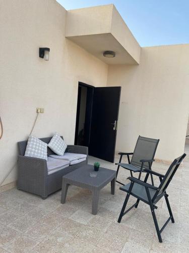 a patio with a couch and two chairs and a table at شقه عائليه بمدخل خاص in Riyadh