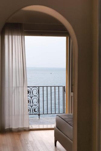 a room with a window with a view of the ocean at Grand Hotel Fasano in Gardone Riviera