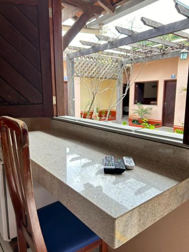 two remote controls sitting on a counter with a window at Agualinda Hotel in Alter do Chao
