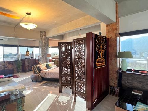 a bedroom with a bed and a living room at Luxury Apartment in Nimman, 5 mins to Maya in Chiang Mai