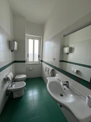 a bathroom with two sinks and two toilets at Hotel La Carruba in Cetraro
