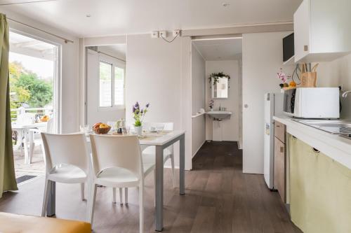 a kitchen with a table and chairs in a kitchen at Club del Sole Vigna sul Mar Family Collection in Lido di Pomposa