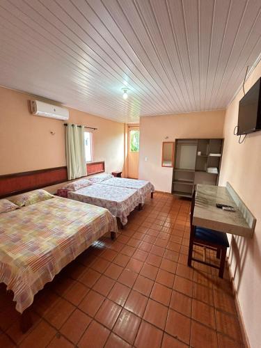a hotel room with two beds and a table at Agualinda Hotel in Alter do Chao