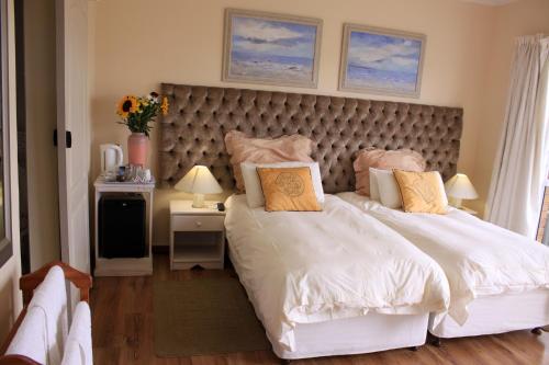 a bedroom with a large bed with a large headboard at Blougans B&B in Gansbaai