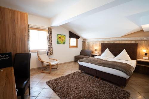 a hotel room with a bed and a chair at Pension Edelweiss in Breitenbach