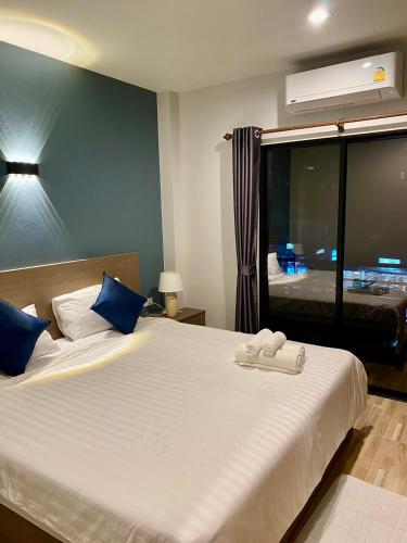 a bedroom with a large white bed with a window at Hm House Patong in Patong Beach