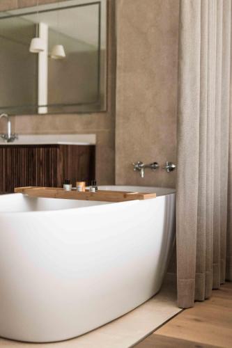 a bathroom with a white tub and a mirror at Grand Hotel Fasano in Gardone Riviera