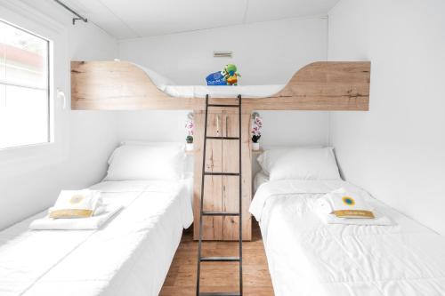 two bunk beds in a room with white walls at Club del Sole Vigna sul Mar Family Collection in Lido di Pomposa