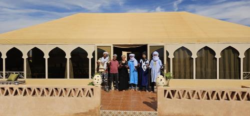 a group of people standing in front of a building at Royal Sahara Dome Camp in Merzouga