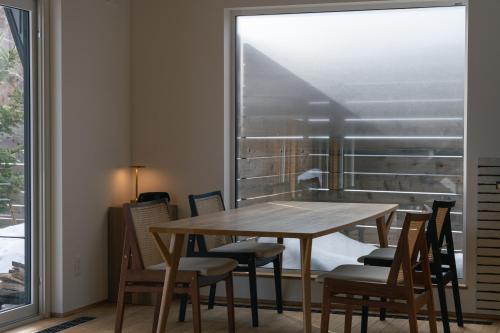 a dining room with a table and chairs and a window at 山郷 Villas in Nature in Otaru