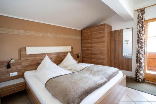 a bedroom with a large bed with a wooden headboard at Pension Edelweiss in Breitenbach