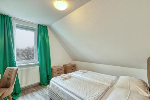 a bedroom with a bed and a window with green curtains at Werrapark Resort Hotel Frankenblick in Masserberg