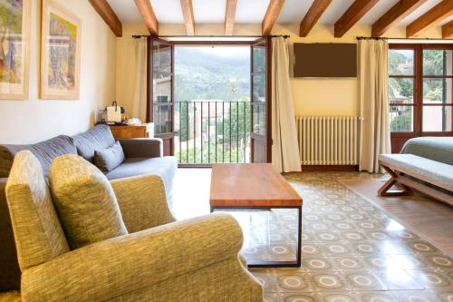 a living room with a couch and a table at Hotel y Apartamentos DES PUIG in Deia