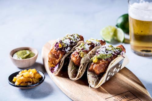 a plate of food with tacos and a glass of beer at JW Marriott Miami Turnberry Resort & Spa in Aventura