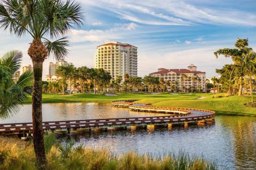 a resort with a lake and palm trees and buildings at JW Marriott Miami Turnberry Resort & Spa in Aventura