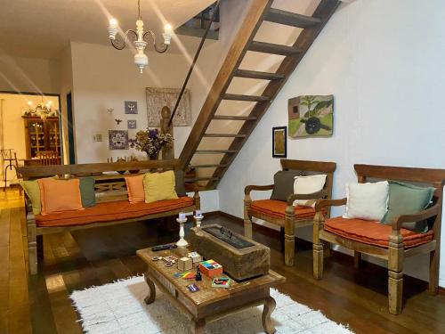 a living room with two couches and a staircase at Cantinho Almeida in Tiradentes