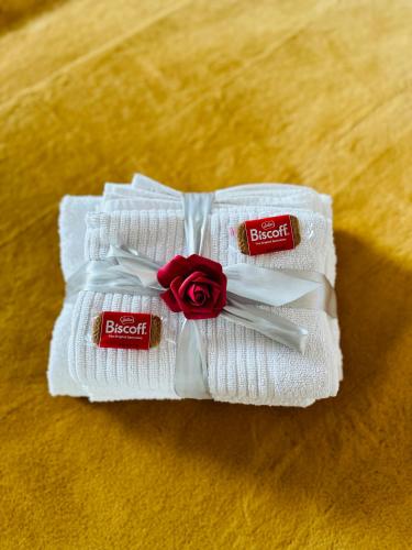 une paire de serviettes blanches avec une rose sur elles dans l'établissement Le Golden-Terrasse & Parking, à Rennes