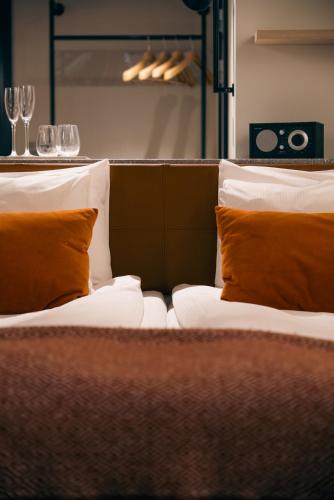 two beds with orange pillows in a room at Marstrands Havshotell in Marstrand