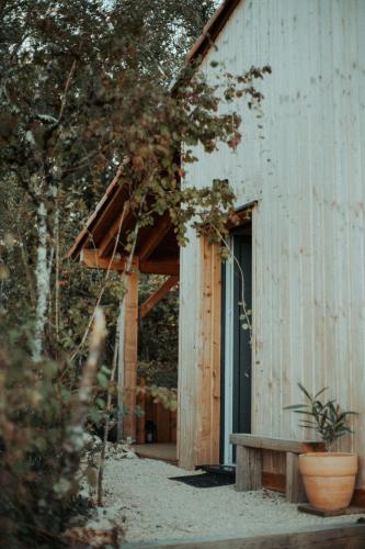 a building with a porch and a bench next to it at Aux Trois Chênes Lodges Spas in Mercuès